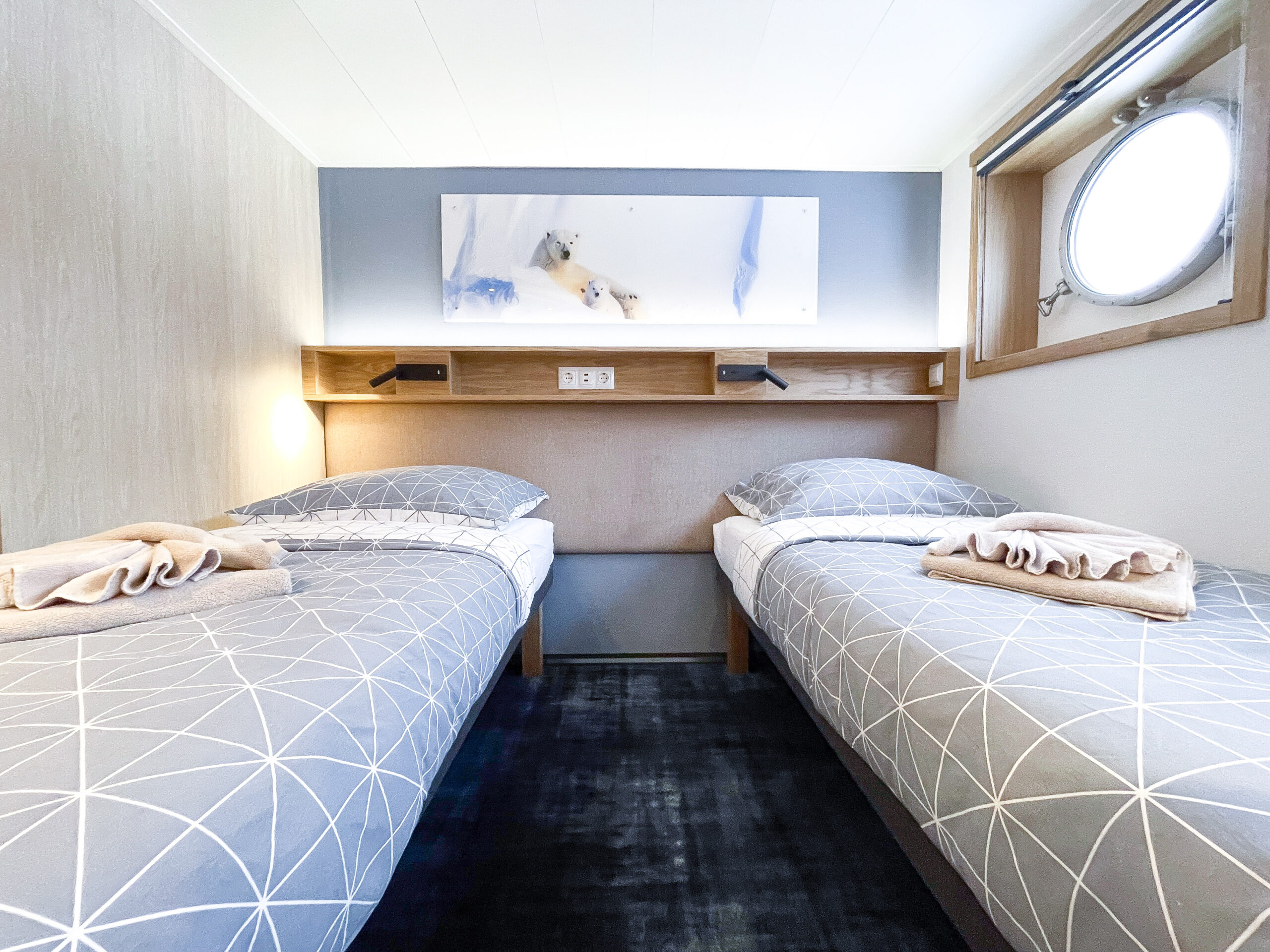 Cabine lits jumeaux avec hublot à bord du Grand Explorer