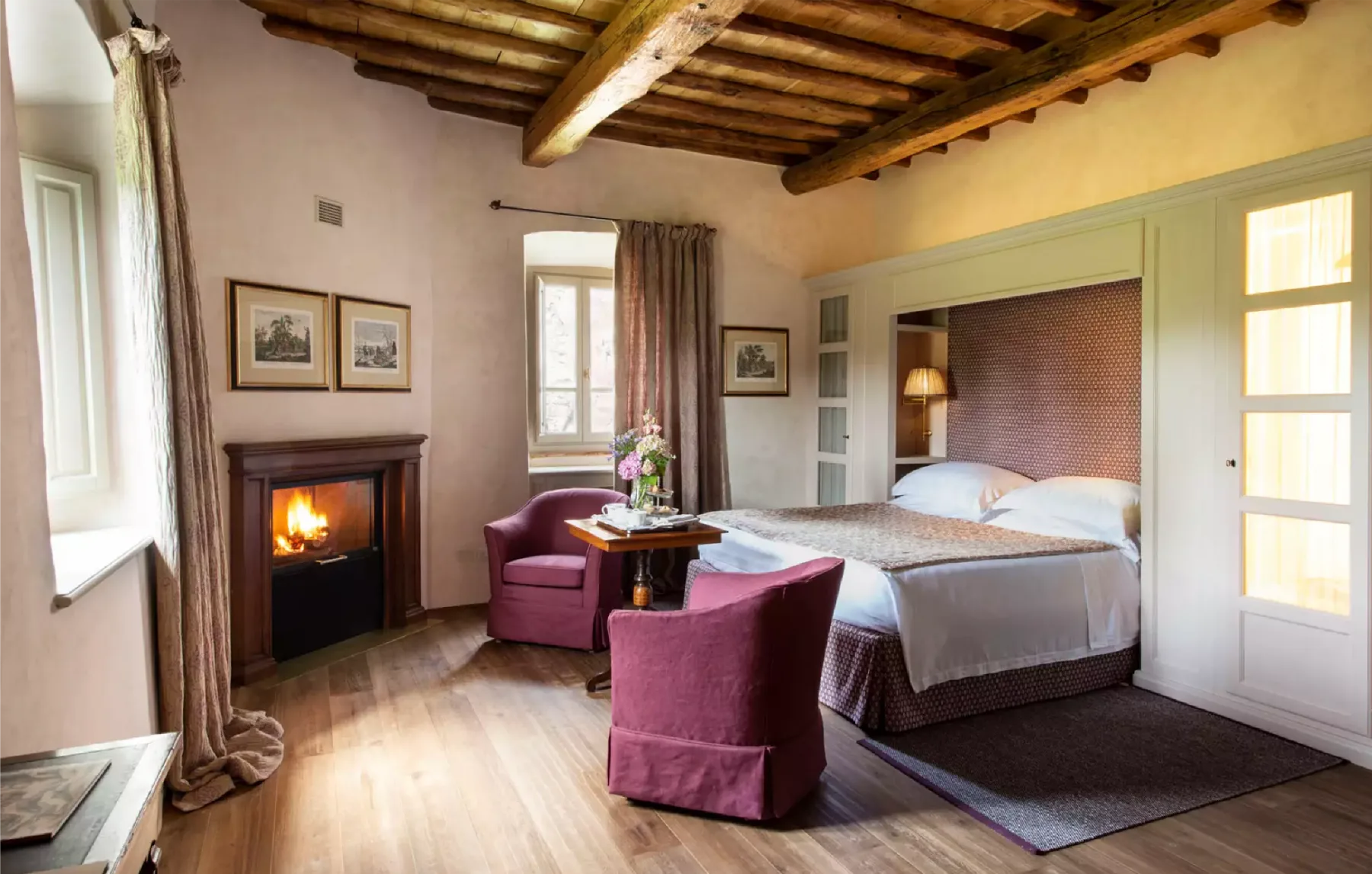 Suite d’Il Borro : poutres apparentes, cheminée allumée et mobilier toscan
